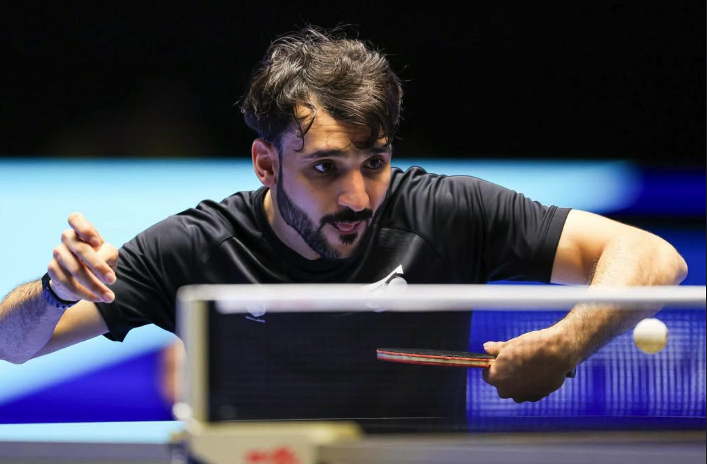 Professional table tennis player showing intense focus and precision during competitive play